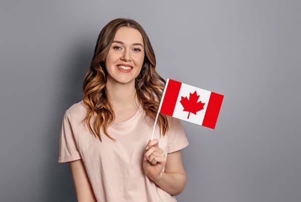 Student Exchange Caucasian Young Student Girl Holds Small Canada Flag Isolated Orange Background Canada Day Holiday Confederation Anniversary Copy Space 600x403