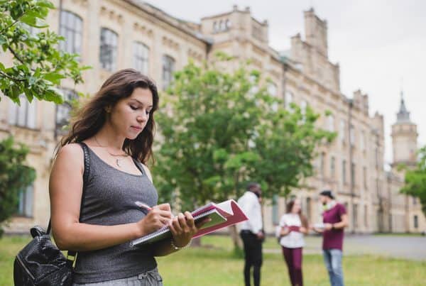 Girl Holding Notebook Writing Standing Outside 600x403